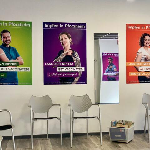 Wartebereich mit Plakatwand und Stuhlreihe