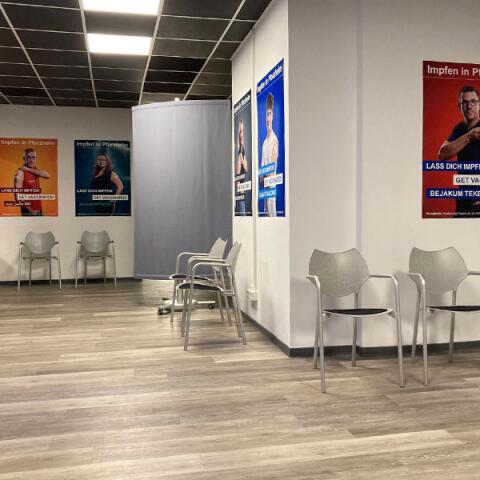 Wartebereich mit Stühlen und Kampagnenplakaten
